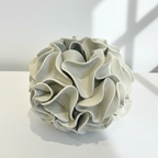 Decorative ceramic vase with ruffled texture on natural white clay