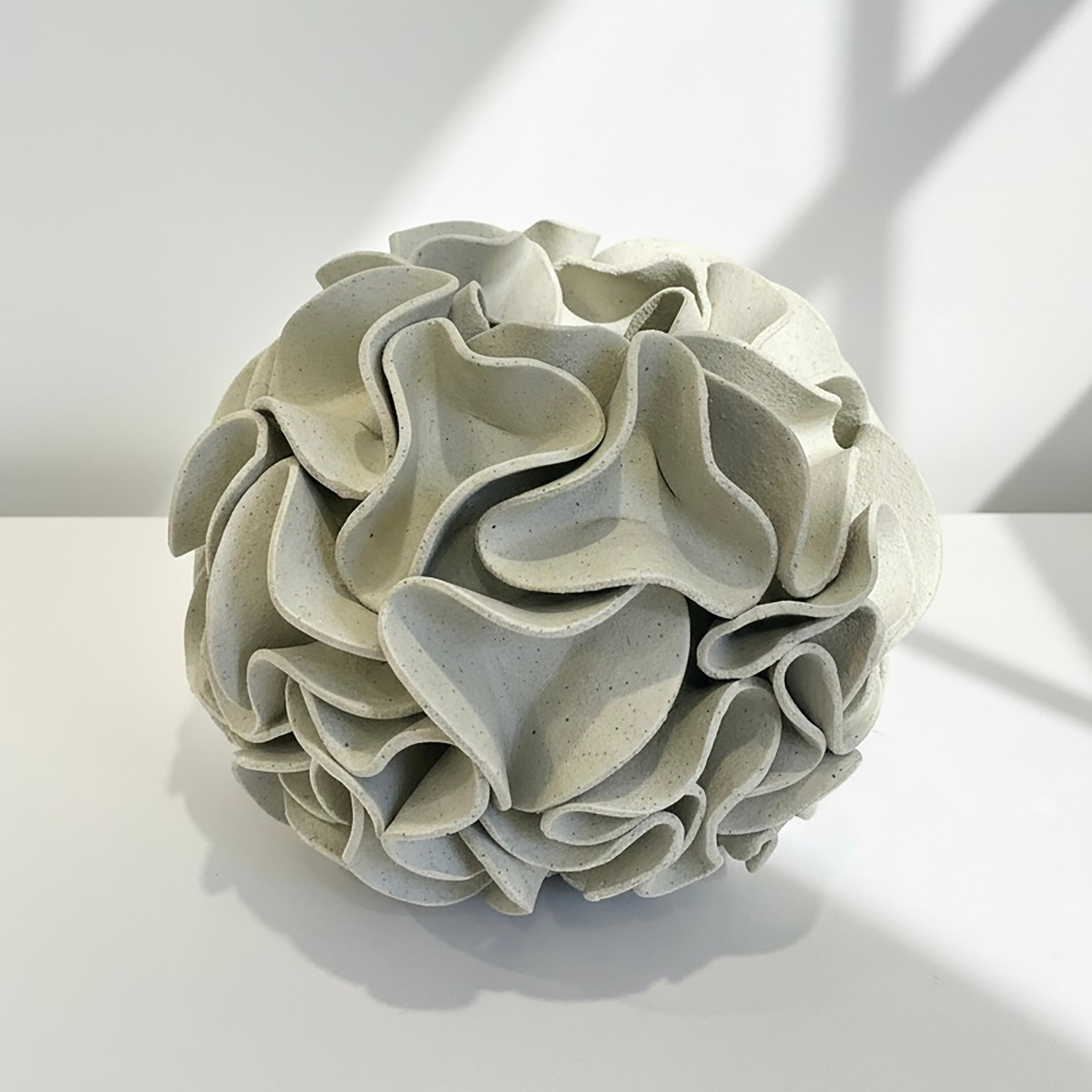 Decorative ceramic vase with ruffled texture on natural white clay