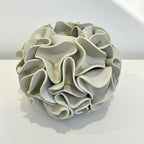 Decorative sphere vase with ruffled texture on natural white clay