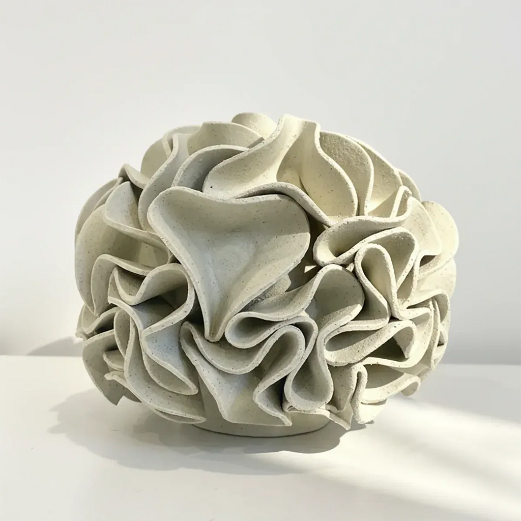 Decorative ceramic vase with ruffled texture on natural white clay