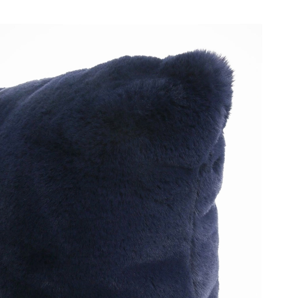 Close-up of a dark navy blue faux fur or sheepskin textured cushion corner against a plain white background.