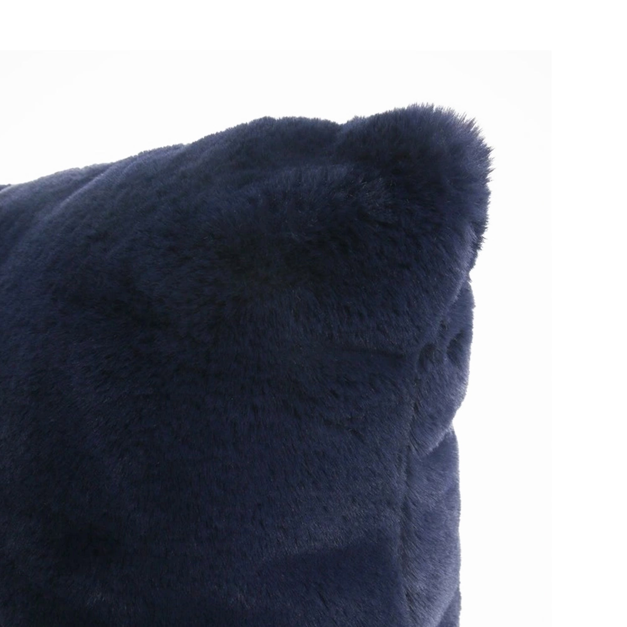 Close-up of a dark navy blue faux fur or sheepskin textured cushion corner against a plain white background.