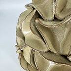 Close-up of a ceramic sculptural vase with layered, ruffled petals or petals-like forms. By Polly Barton.