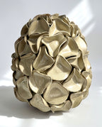 A sculptural egg-shaped decorative vase in melted mint glaze, overlapping petal-like surface folds.