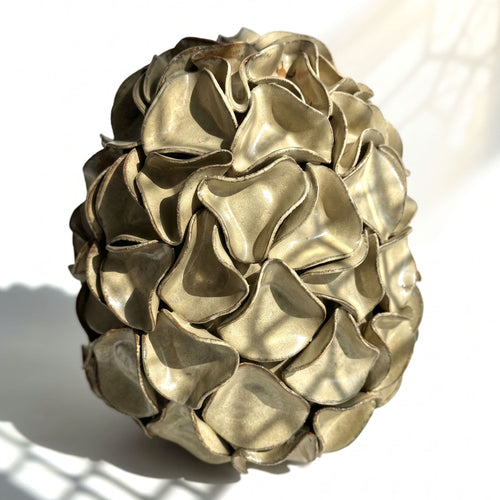 A very large and heavy decorative sculpture resembling a textured egg, composed of overlapping ruffled scales. In Melted mint glaze.