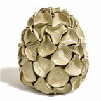 A very large decorative ceramic sculpture resembling a stylized egg, composed of overlapping petal-like scales, shown on a plain white background. By Polly Barton