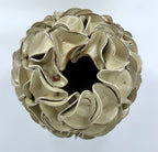 A sculptural egg-shaped decorative vase in melted mint glaze, overlapping petal-like surface folds, photographed from directly above.