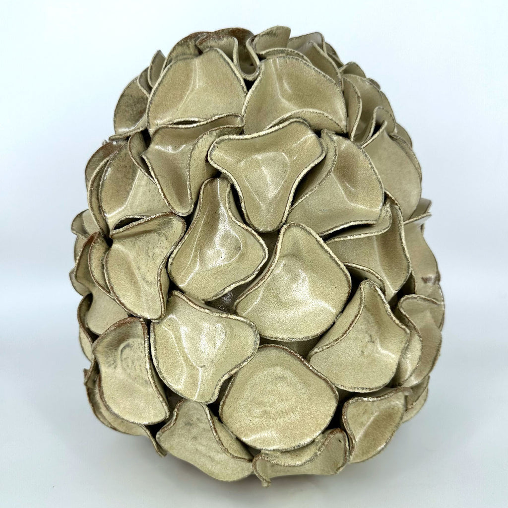 A sculptural egg-shaped decorative ceramic vase in melted mint glaze, overlapping petal-like surface folds. By Polly Barton