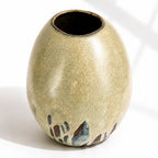 A large ceramic vase with a rounded, egg-shaped form, featuring a textured mint and beige glaze with dark brown and blue leaf-like accents near the base.