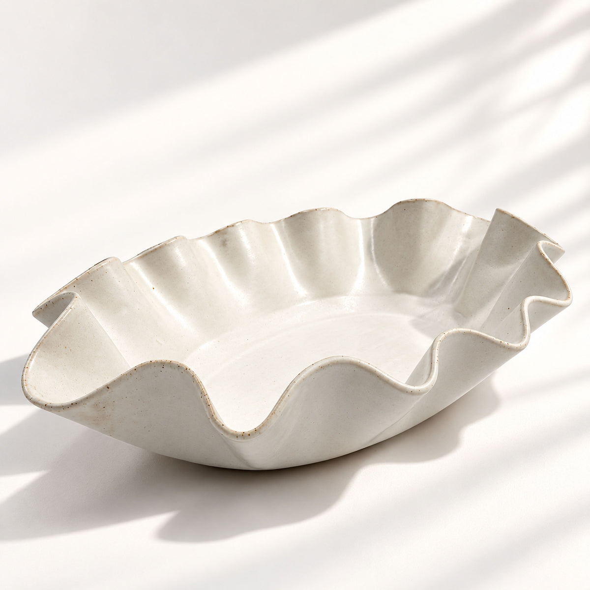 Sculptural white ceramic fruit or serving bowl, handcrafted with a flowing wave-shaped edge and a beautiful organic form