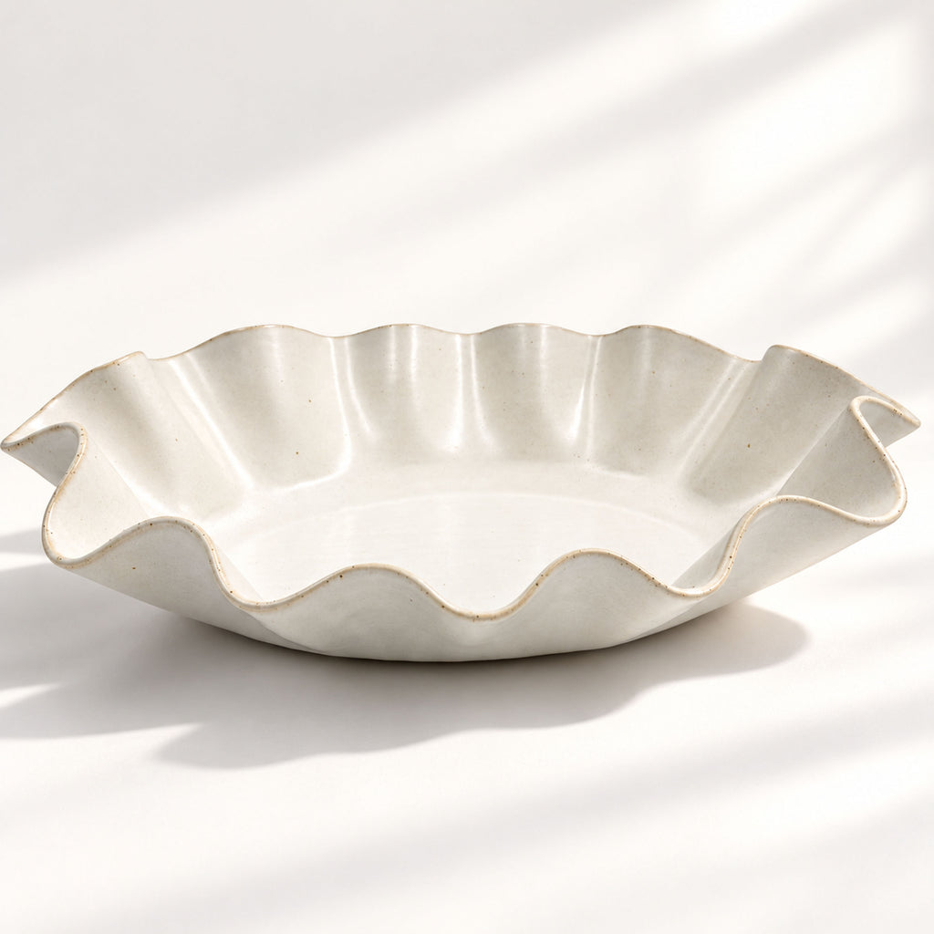 Hand-built white ceramic serving bowl featuring a sculptural wave rim, soft curves and flat base