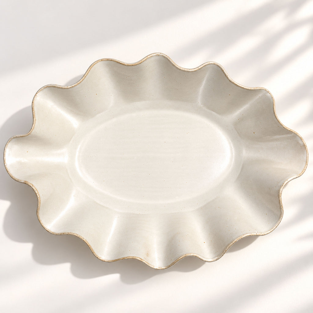 Large handmade stoneware serving bowl in a white satin glaze, with an elegant undulating rim inspired by coastal waves