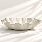 Large handmade stoneware serving bowl in a white satin glaze, with an elegant undulating rim inspired by coastal waves