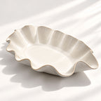 Large handmade stoneware serving bowl in a warm white glaze, with an elegant undulating rim inspired by coastal waves