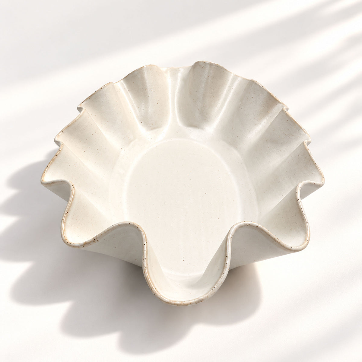 Sculptural white ceramic fruit or serving bowl, handcrafted with a flowing wave-shaped edge and a beautiful organic form