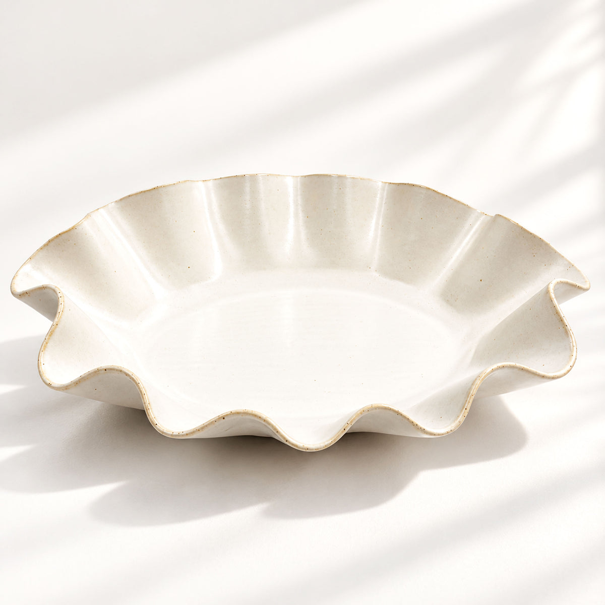Sculptural white ceramic fruit or serving bowl, handcrafted with a flowing wave-shaped edge and a beautiful organic form