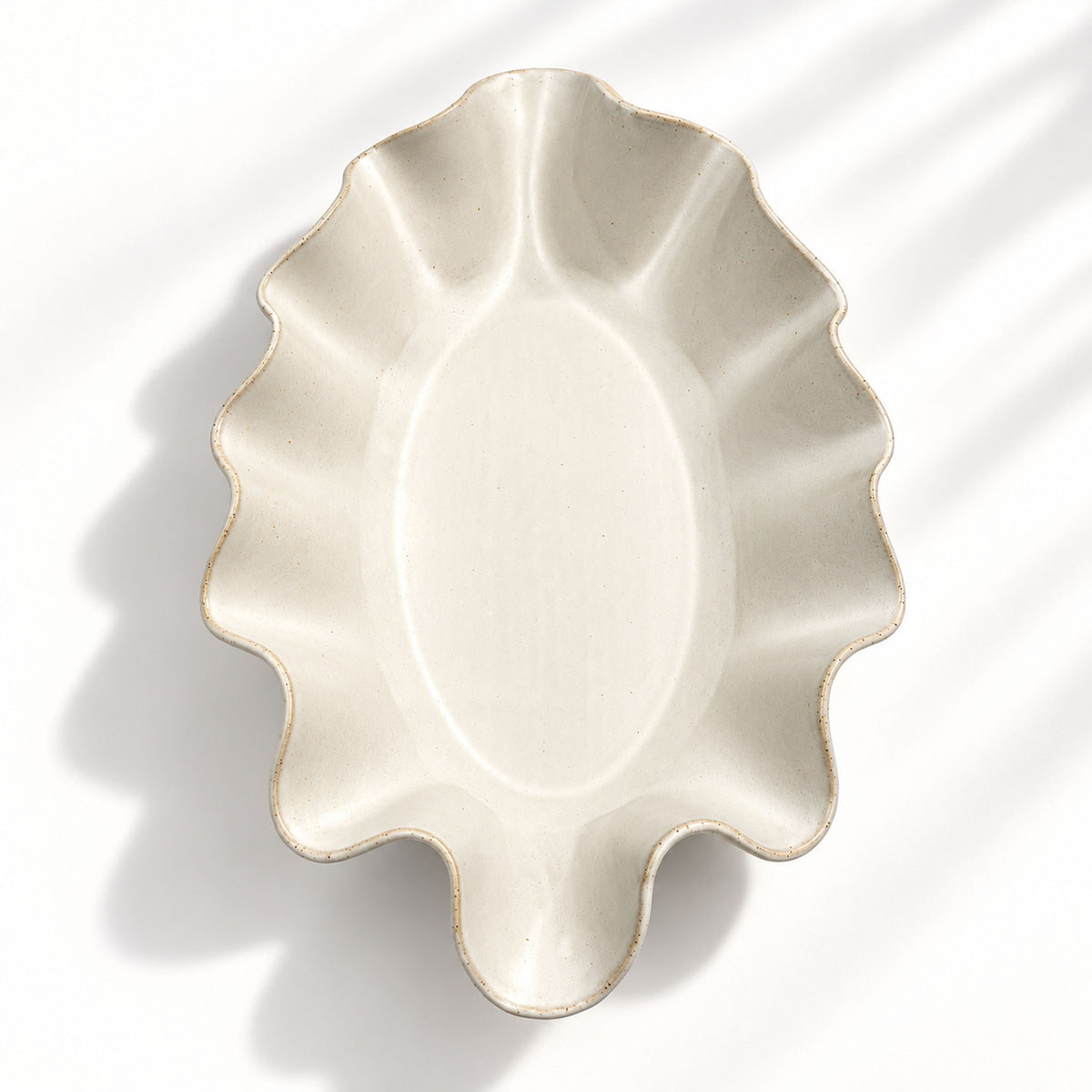 Sculptural white ceramic fruit or serving bowl, handcrafted with a flowing wave-shaped edge and a beautiful organic form